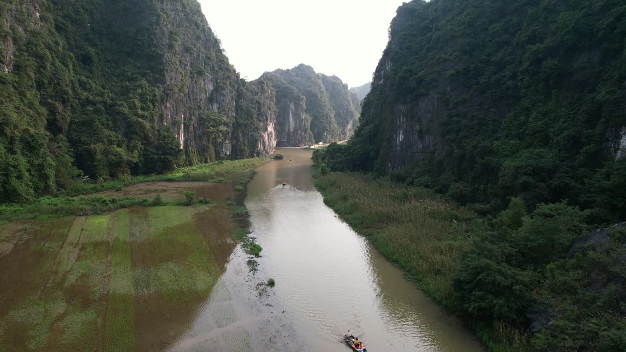 ninh binh 국립 공원의 석회암 계곡에서 ngo dong 강에서 노를 젓는 관광 보트 관광객, 강둑에 범람 된 논 - 공중 돌리