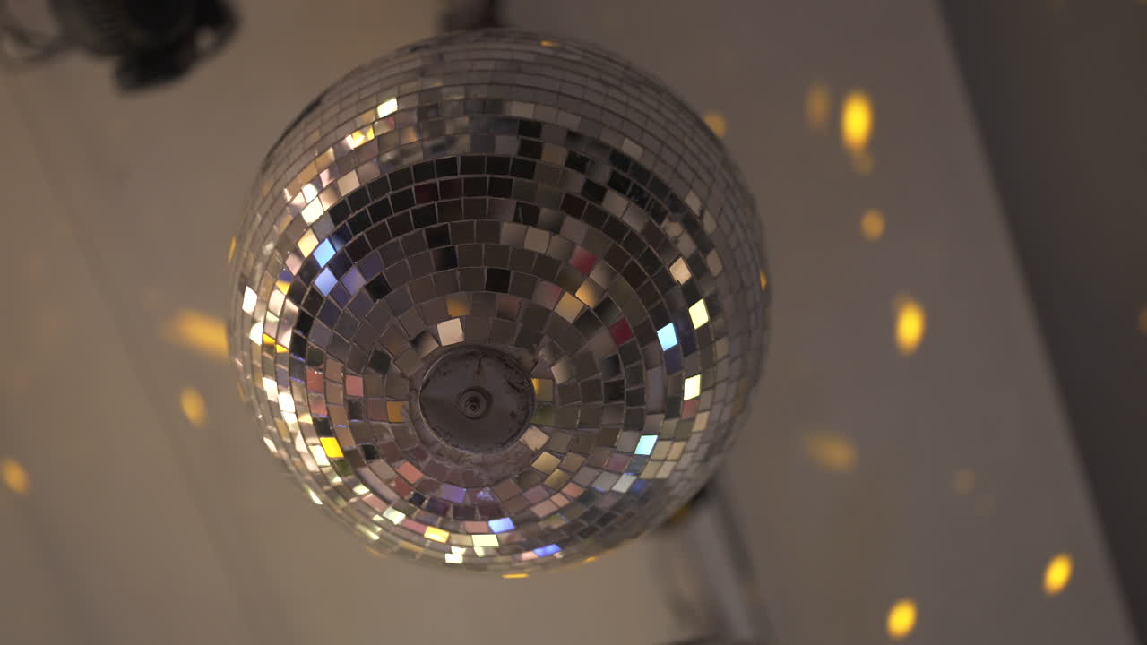 una bola de discoteca reluciente refleja puntos de luz a través de una habitación, creando un ambiente de fiesta