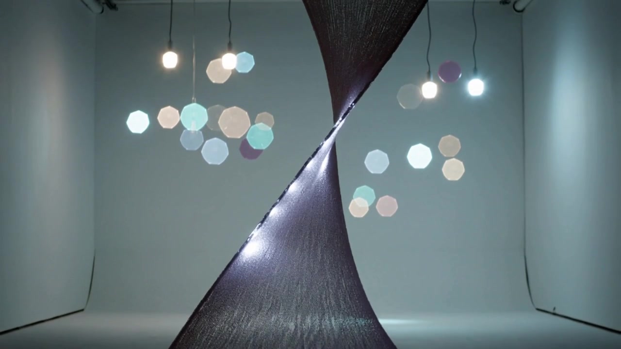 Pulling motor lifting filament sculpture upward in gallery, forming LED double helix with bulbs