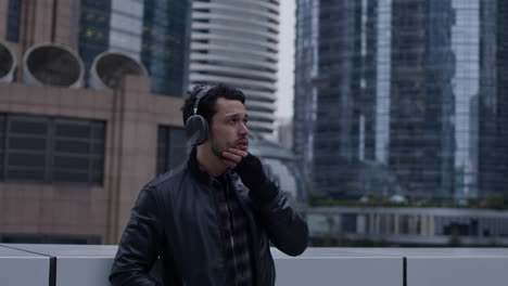 aspiring caucasian man looks around at skyscrapers in downtown urban area