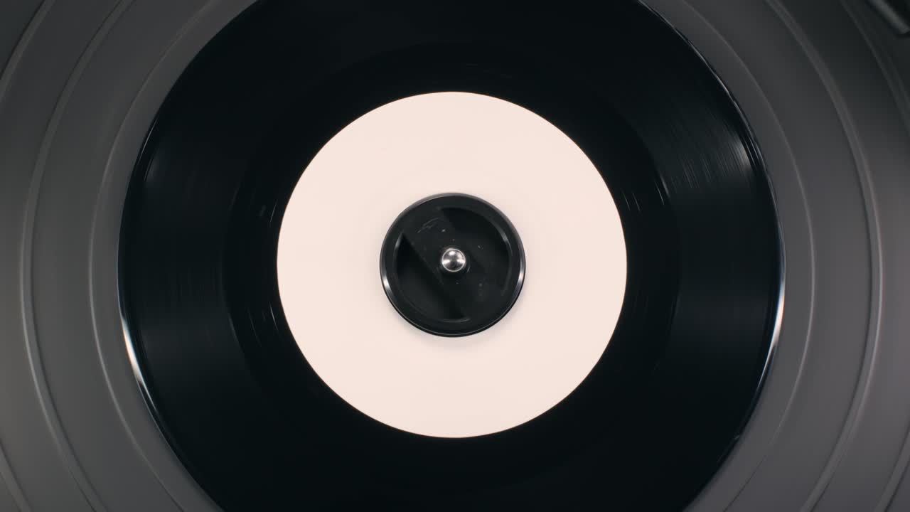 Retro Vinyl record player playing music, close-up macro shot of vintage LP disc old phonograph spinning. Retro music player.