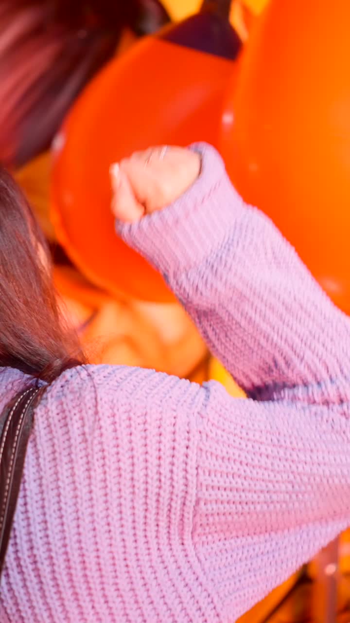 A person interacting with large orange balloons