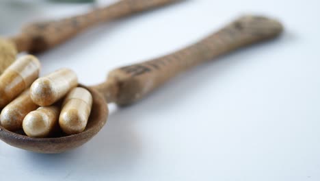 herbal medicine capsule and powder on spoons