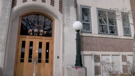 union building on the campus of michigan state university, site of a mass shooting in 2023 with gimbal walking forward on side entrance