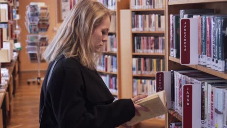 young girl chose a book from library, checked it and returned it back