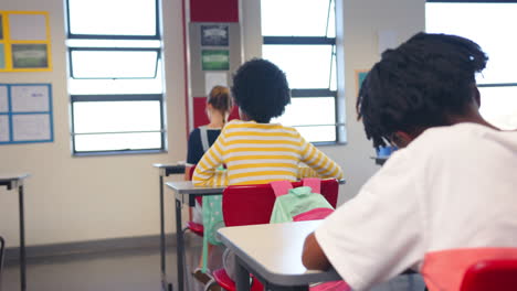 in school, students sitting at desks and focusing on their work