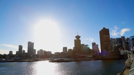 Establishing-shot-of-Vancouver-downtown-with-Top-of-Vancouver,-seagulls-flying,-and-Canada-Place-+-Canadian-flag-blowing-in-wind