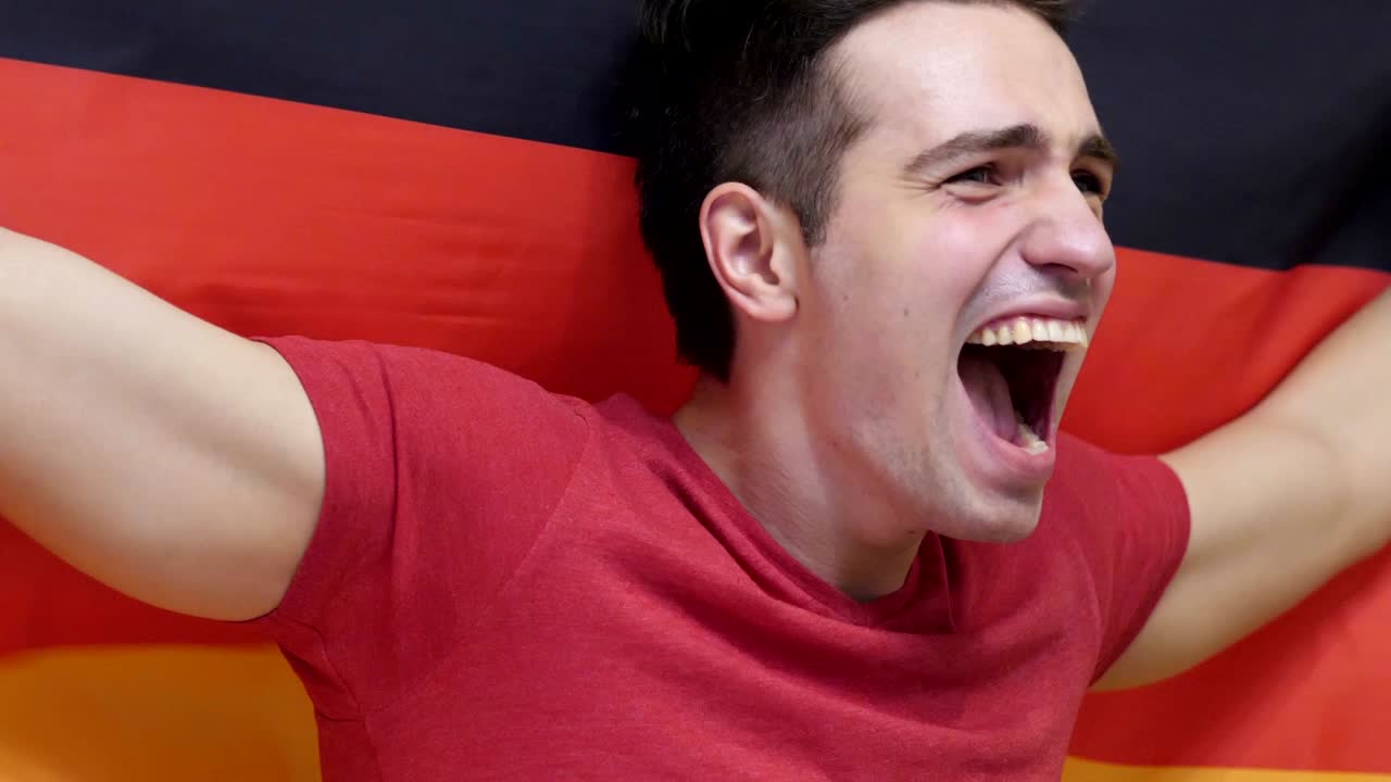 독일의 발을 느린 속도로 들고 축하하는 젊은 독일인