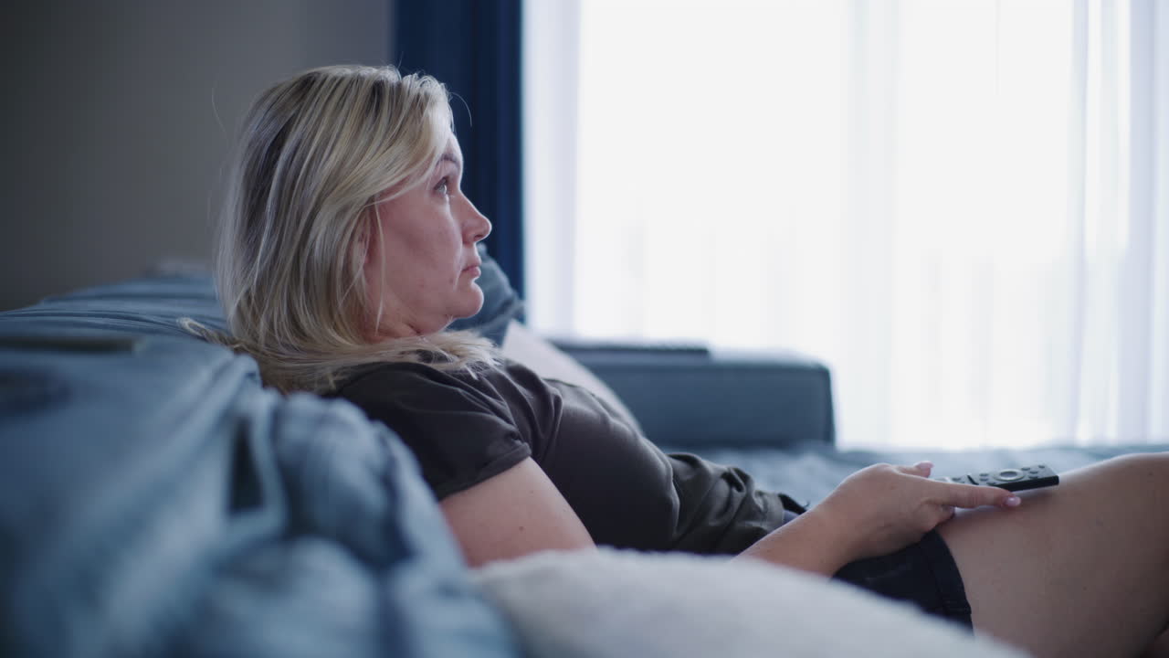 소파에서 tv를 보는 여자