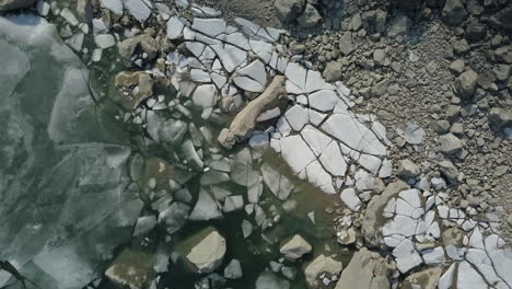 rising overhead shot of large chunks of ice at the shoreline of a lake in norway