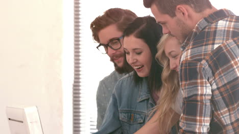 equipo de hipsters riendo viendo un monitor de pc