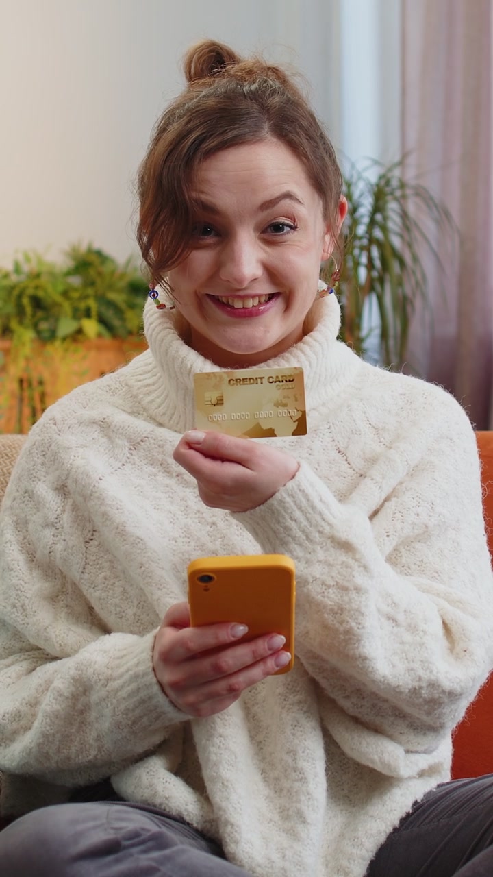 Young woman using credit bank card and smartphone transferring money purchases online shopping