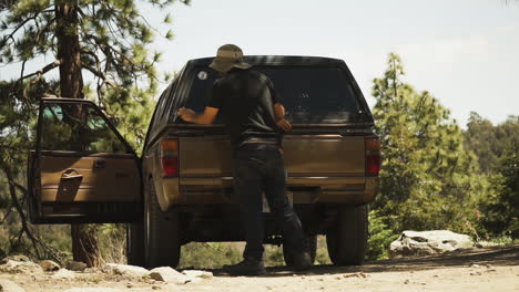 Slow-motion-shot-of-a-guy-locking-up-his-car-door-after-packing-up-his-luggage-while-leaving-for-pleasant-valley,California,USA-on-a-bright-sunny-day