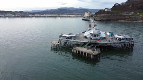 elegant stretching victorian welsh llandudno pier aerial view fast orbit right shot on quiet morning