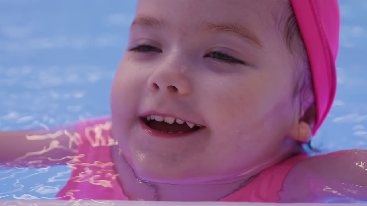 아이가 밝은 미소로 풀장에서 물놀이를 즐기고, 물을 튀기며 놀고 있어요. 맑고 푸른 물결이 일렁이고, 돌보는 사람이 부드럽게 아이를 지지해줘요. 깨끗하고 반짝이는 환경에서 안심하고 움직이며, 수영을 일찍 시작해 자신감을 키우고 있어요.