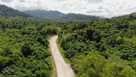 Motorbike-driving-at-an-empty-street-in-forest-jungle