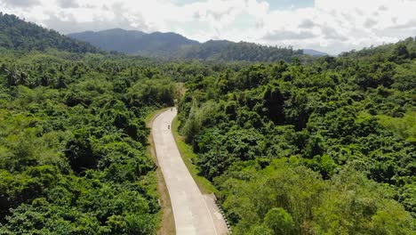 motorbike driving at an empty street in forest-jungle