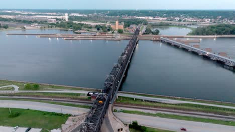 downtown davenport, iowa railroad bridge over mississippi river and train moving with drone video moving forward