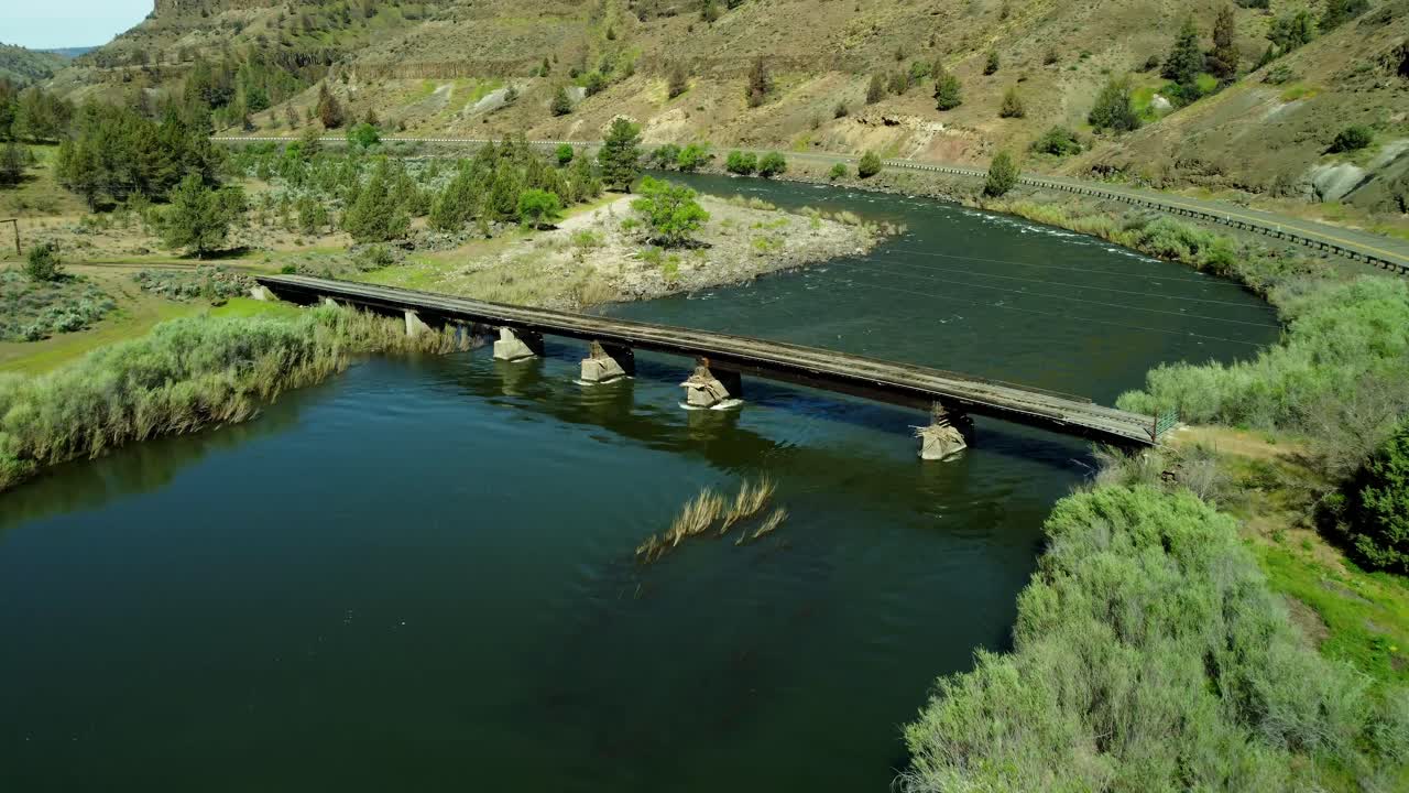 US, Oregon, Spray, Service Creek, 2025-05-07 - Drone view of a private gated wooden bridge crossing Service Creek in north central Oregon. It leads deep into the mountains to a ranch