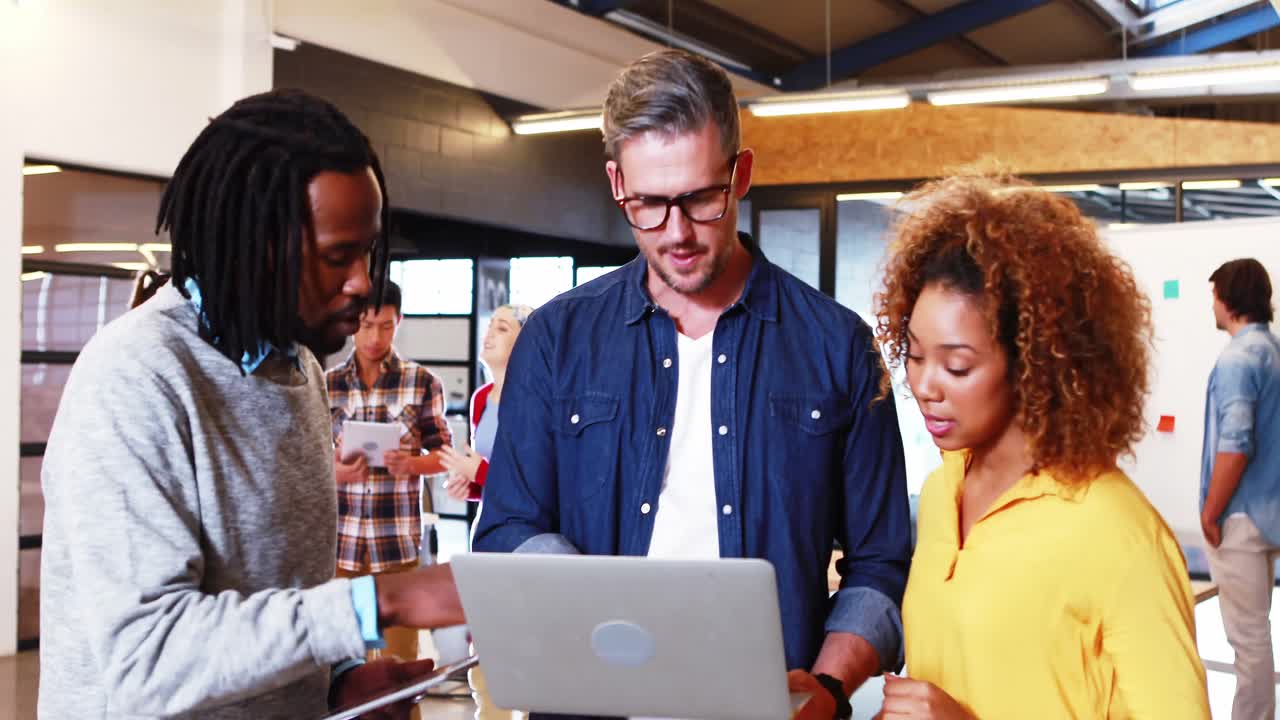 Business people discussing over laptop