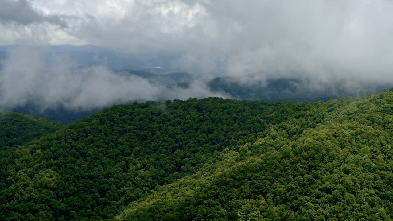 Cinematic flight through mist and clouds converging on Smoky peaks