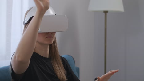 Junge-Benutzerin-Nutzt-Head-Mounted-Display-Zu-Hause,-Betrachtet-Den-Bildschirm-Und-Drückt-Virtuelle-Tasten.-Junge-Dame-Mit-VR-Headset-Im-Zimmer