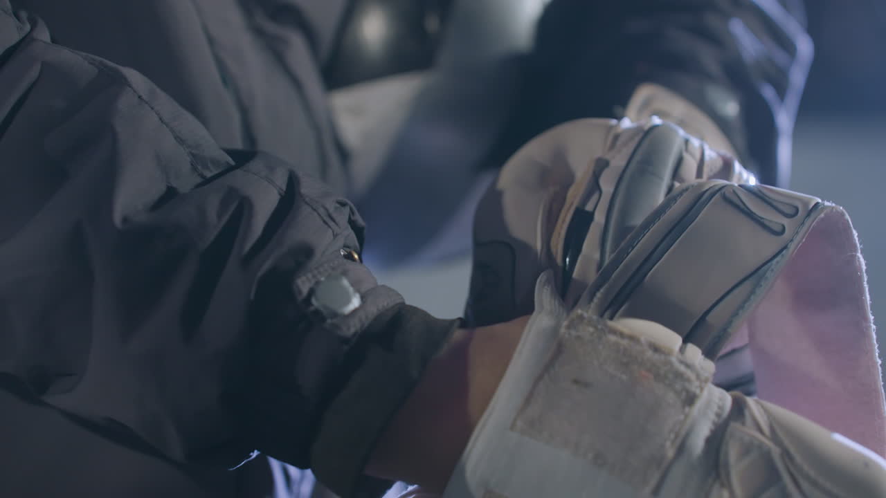 도시 환경에서 스포츠 세션을 준비하는 동안 손을 단단히 는 장갑의 클로즈업, 부드러운 조명 효과를 특징으로하는 흐릿한 배경