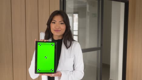 beautiful-asian-woman-holding-tablet-smiling-vertical-wooden-background