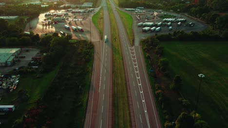 Magic-aerial-of-semi-truck-on-interstate-between-service-plaza-area