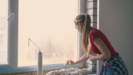 pretty girl cleans frame of new window in empty apartment