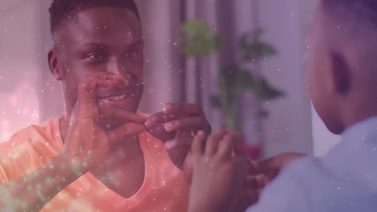 Animation of lights over happy african american father and son playing finger games