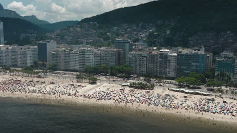 inclinación aérea hacia abajo disparó al turista en la concurrida playa de copacabana en río de janeiro con panorama del paisaje urbano