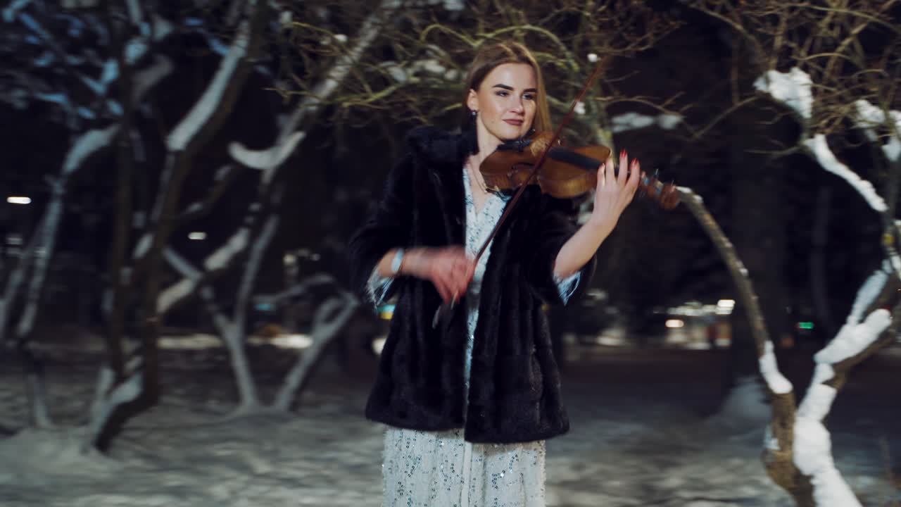 Street musician playing on violin. Musician girl singing melody on his violin
