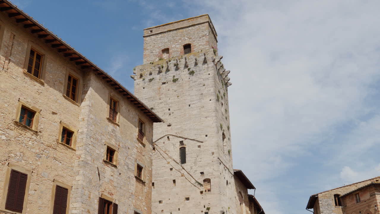 Giornata di sole a San Gimignano sopra storici edifici in pietra toscani con cielo azzurro limpido