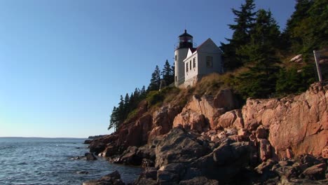 a lighthouse on the edge of a cliff overlooking the ocean in bass harbor lighthouse maine 2