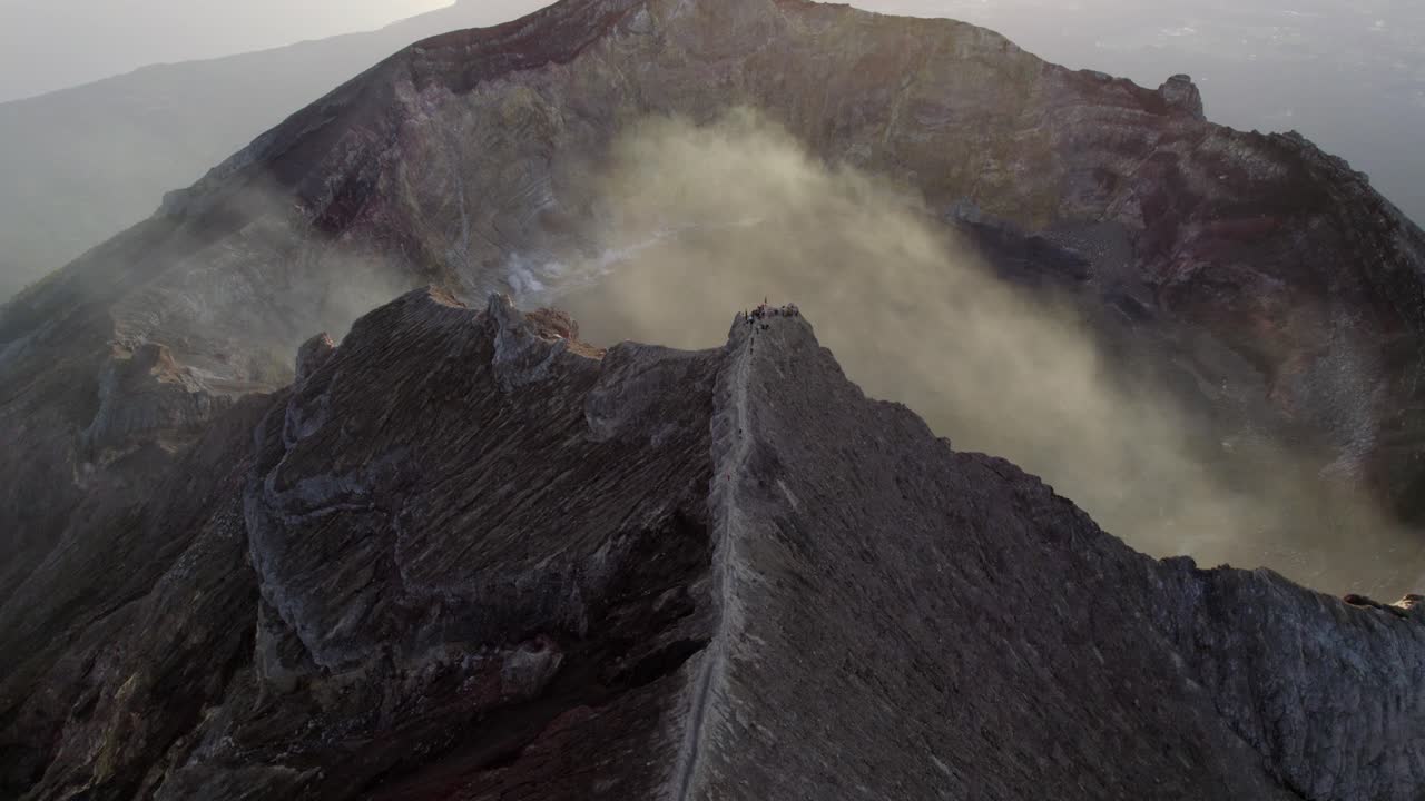 Cratere vulcanico con vapore visibile e interno roccioso, Monte Agung Indonesia, ripresa aerea media all'alba.