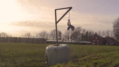 Paar-Gummistiefel-Hängen-Bei-Sonnenuntergang-über-Dem-Feld-Während-Des-Bauernprotestes-In-Rheinland-Pfalz,-Deutschland