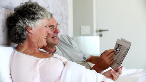 Mature-couple-solving-crossword-in-the-bed