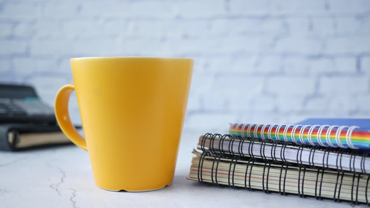 escritorio de oficina con taza de café y cuadernos