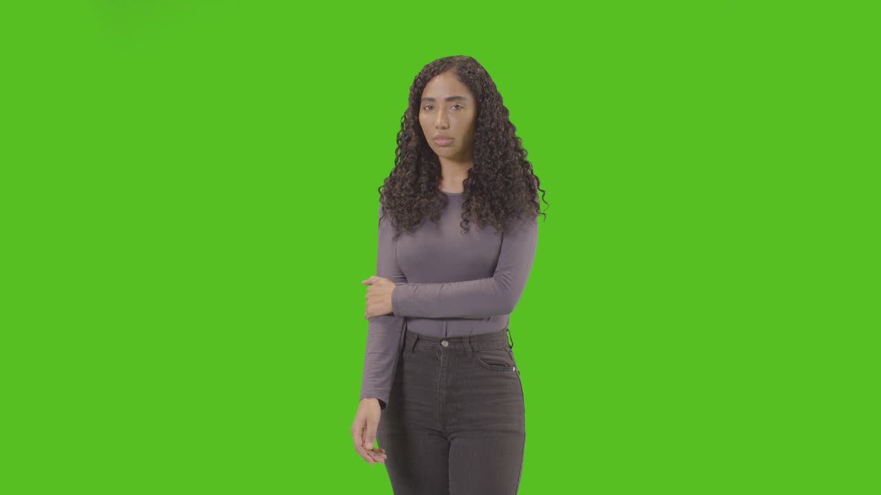 Three Quarter Length Portrait Of Sad Looking Woman Against Green Screen