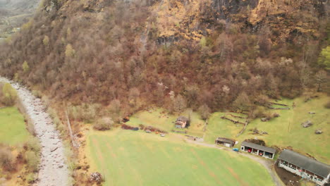 Fly-Over-The-Maggia-River-Near-Cevio-Village-With-Autumnal-Forest-Mountains-In-Switzerland