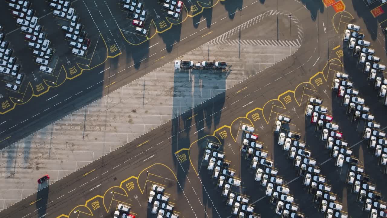 Aerial ascend over huge car manufacturer company parking lot