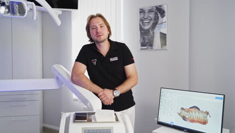 doctor specializing in dental treatment. male dentist in dental office talking to camera