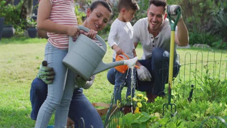 Glückliche-Kaukasische-Familie,-Die-Gemeinsam-Im-Garten-Arbeitet-Und-Pflanzen-Gießt