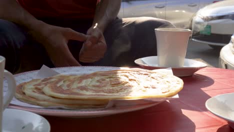 enjoying roti canai and tea for breakfast
