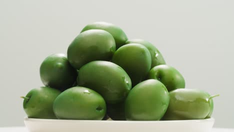 aceitunas verdes redondas en vinagre de grecia como fondo, vista de arriba. imágenes de alta calidad en 4k