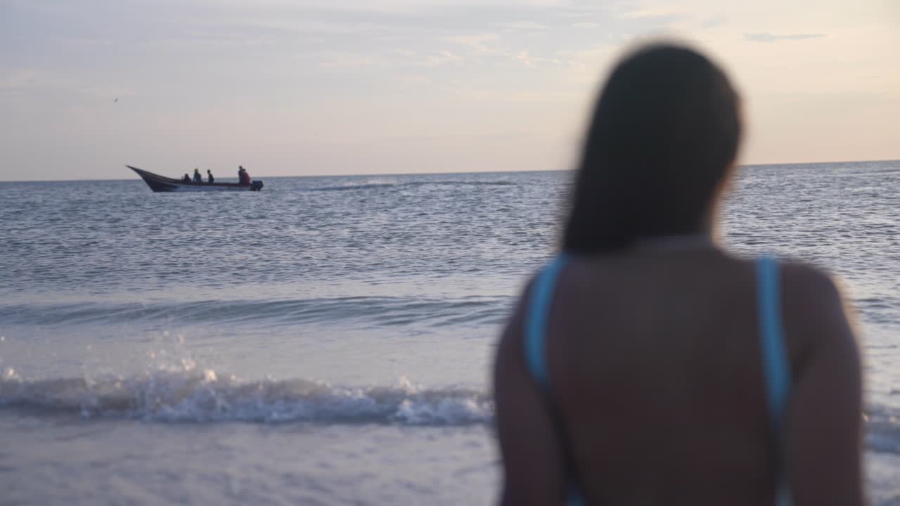 베네수엘라의 코체 섬에서 해가 지는 바다를 바라보는 라틴계 여성들