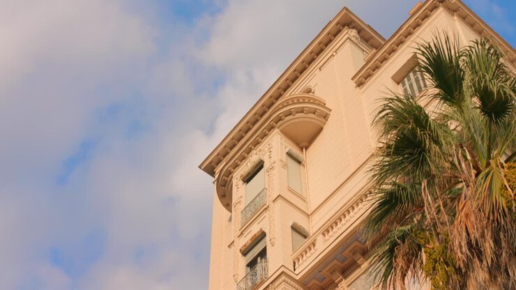 Scopri l'architettura unica del Riviera Palace a Mentone, in Francia. La camera cattura dettagli mozzafiato e un ambiente vivace, mettendo in risalto le caratteristiche storiche sotto un cielo limpido.
