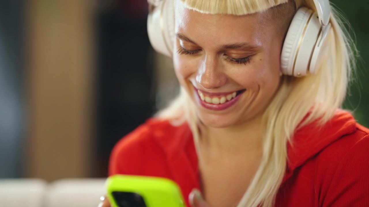 Giovane donna con le cuffie che usa lo smartphone