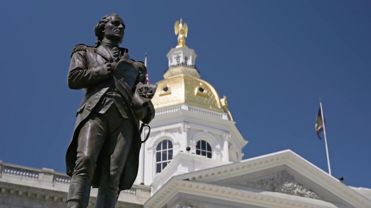 Movimento cinematografico di dolly all'indietro e verso il basso che rivela la statua del Generale John Stark nel parco della New Hampshire State House a Concord, New Hampshire, durante una luminosa giornata estiva